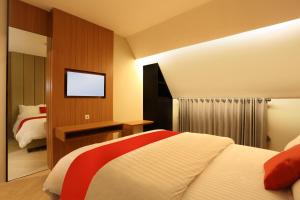 a hotel room with a bed and a flat screen tv at Adotel in Jakarta