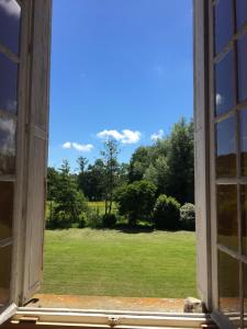 ein offenes Fenster mit Blick auf ein Feld in der Unterkunft Chambres d'Hôtes & Gites La Chatellenie in Saint-Aubin-le-Cauf