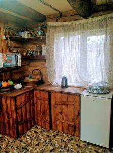 eine Küche mit Holzschränken und einem Fenster in der Unterkunft Котедж ,,Чудовий"з банькою in Novaya Greblya