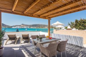 a patio with a table and chairs and the water at Michalakis Seaside Suites in Pollonia