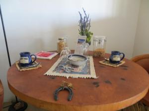 a wooden table with a bowl and cups on it at Rancho Milagro Bed & Breakfast in Elgin