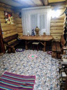 een woonkamer met een houten tafel en een tapijt bij Котедж ,,Чудовий"з банькою in Novaya Greblya