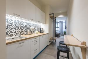 a kitchen with white cabinets and a counter with stools at Filia Place in Athens
