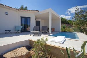 een achtertuin met een zwembad en een huis bij Les Villas de la Résidence U Veniqui in Favone