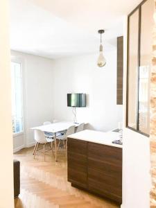 Habitación blanca con mesa y comedor en Buffa Résidence, en Niza