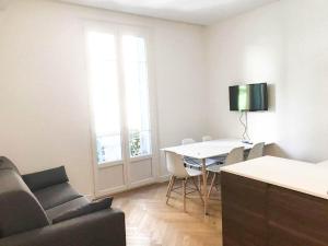 sala de estar con mesa, sillas y sofá en Buffa Résidence, en Niza