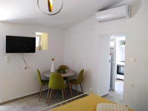 a room with a table and chairs and a tv on the wall at Casa Bellissima in Chania
