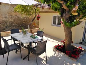 a table and chairs on a patio with a tree at Casa Bellissima in Chania