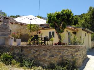 a house with an umbrella and a stone wall at Casa Bellissima in Chania