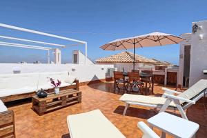 a patio with white furniture and an umbrella at 053 - Altomar II 003 - comfortHOLIDAYS in Gran Alacant