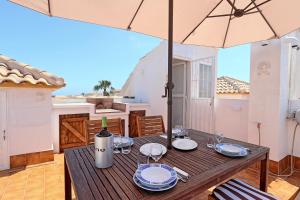 a wooden table with an umbrella on a balcony at 053 - Altomar II 003 - comfortHOLIDAYS in Gran Alacant