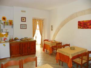 a kitchen and dining room with two tables and a refrigerator at Cloris Guest House in Noto