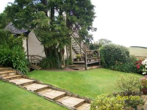 einen Garten mit einer Treppe und einer Liegewiese in der Unterkunft Frogwell in Strete