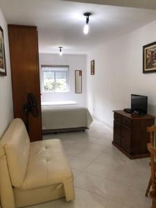 a living room with a chair and a bed at Waldorf Service in Sao Paulo