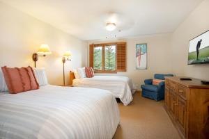 a bedroom with two beds and a blue chair at 326 Kiva Condo access to Ski in Out in Avon +31 photos