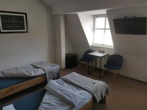 um quarto com duas camas e uma mesa e duas cadeiras em Bemma Apart Hostel em Breslávia