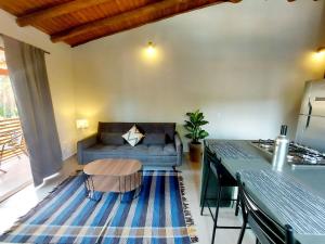 una sala de estar con un sofá y una mesa en Mamanguá - Apto c/ piscina, 50mts da praia, cozinha, churrasqueira, ar con, WiFi, netflix, garagem, en Paraty
