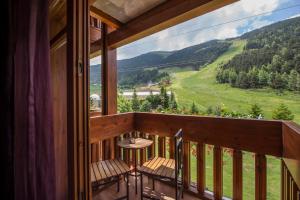 a balcony with chairs and a view of a mountain at Hotel Nordic in El Tarter