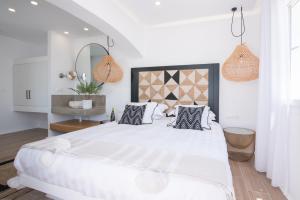 biała sypialnia z dużym białym łóżkiem z poduszkami w obiekcie Divine Naxos Villa w mieście Plaka