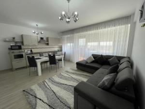 a living room with a black couch and a kitchen at Class DeLuxe Apartments in Oradea