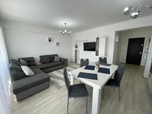 un soggiorno con divano e tavolo con sedie di Class DeLuxe Apartments a Oradea