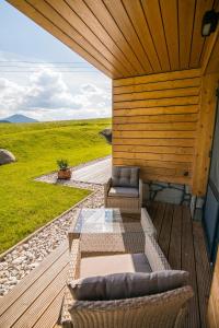 a patio with two couches on a wooden deck at Apartmány Tatry Žiarce in Liptovský Mikuláš