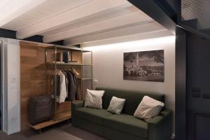 ein Wohnzimmer mit einer grünen Couch und einem Schrank in der Unterkunft Agriturismo Le Grazie in Verona