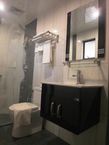 a bathroom with a sink and a toilet and a mirror at Mandarin Hotel Kota Kinabalu in Kota Kinabalu