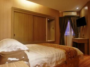 Rúm í herbergi á Mandarin Hotel Kota Kinabalu