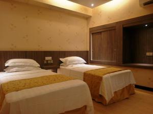 una camera d'albergo con due letti e una finestra di Mandarin Hotel Kota Kinabalu a Kota Kinabalu