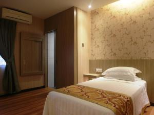 Rúm í herbergi á Mandarin Hotel Kota Kinabalu