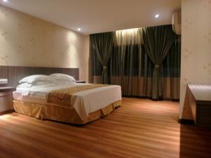 Rúm í herbergi á Mandarin Hotel Kota Kinabalu