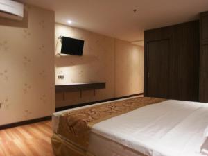Rúm í herbergi á Mandarin Hotel Kota Kinabalu