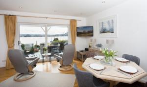 a living room with a table and chairs and a large window at Fishermans in Inverness