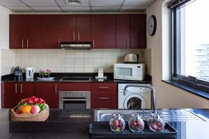a kitchen with brown cabinets and a sink with fruit on it at HiGuests - Modern Apt in Dubai Marina With Pool and Gym in Dubai