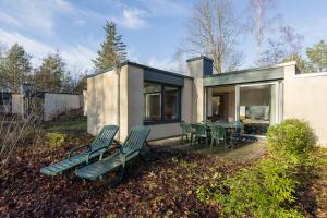 a house with green chairs on a patio at Center Parcs Bispinger Lüneburger Heide in Bispingen