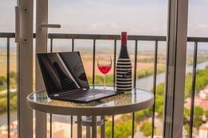 a laptop and a glass of wine on a table on a balcony at Spondylus II in Empuriabrava