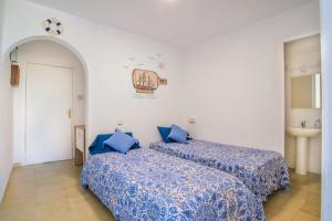 two beds in a room with blue sheets at Spondylus II in Empuriabrava