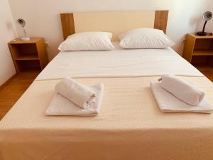 Una cama con dos almohadas blancas encima. en Bibinje SeaSide Apartment, en Bibinje
