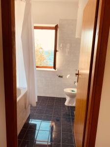 baño con aseo y ventana en Bibinje SeaSide Apartment, en Bibinje