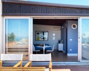 a house with sliding glass doors and a table and chairs at Osservatorio sul mare in Bari