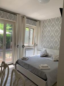 1 dormitorio con 1 cama con 2 sillas y una ventana en B&B Giordano, en Porto SantʼElpidio