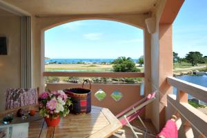 een balkon met een tafel en uitzicht op het water bij Cala di Sole Lecci in Porto-Vecchio