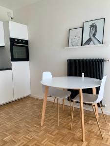 a kitchen with a white table and two chairs at Appartement 509 in Klagenfurt