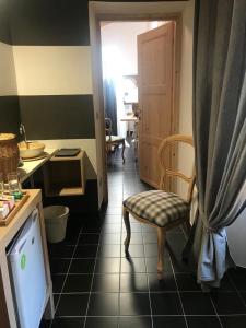 a kitchen with a chair and a sink and a door at Sanctus Syrus 2 in Albenga