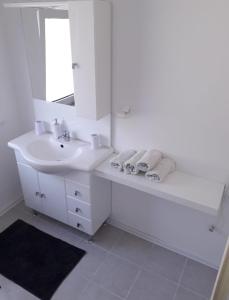 a white bathroom with a sink and a mirror at Apartment Relax in Vir +15 photos