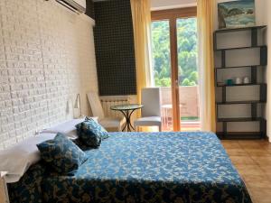 a bedroom with a bed with blue sheets and a window at Affittacamere Alle 5 Terre in Monterosso al Mare