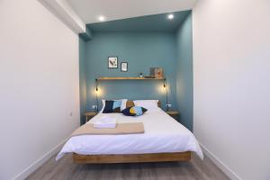 1 dormitorio con 1 cama grande y paredes azules en hotelise I Blue-Poppy Apartment, en Ereván