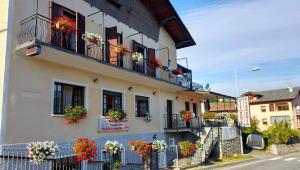 ein Gebäude mit Blumenkästen auf den Balkonen in der Unterkunft Locanda mami in Aosta