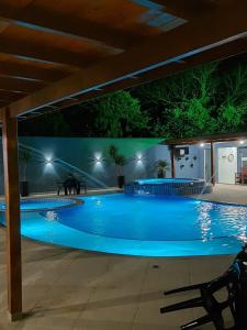 a large blue swimming pool at night at Pousada Recanto da Cascata in Águas de Lindóia